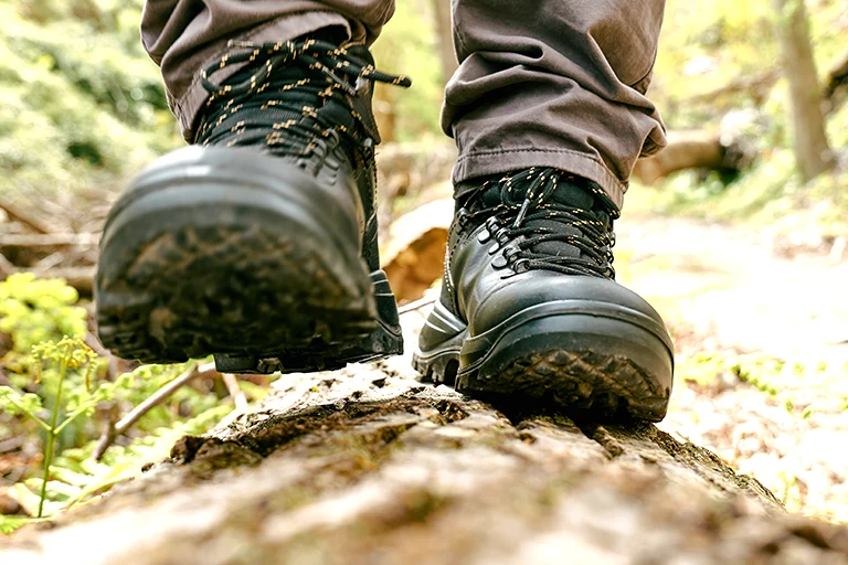 Hiking in forest wearing safety footwear.
